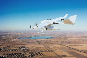 Image of a Wingcopter delivery craft with a parcel or package while flying.