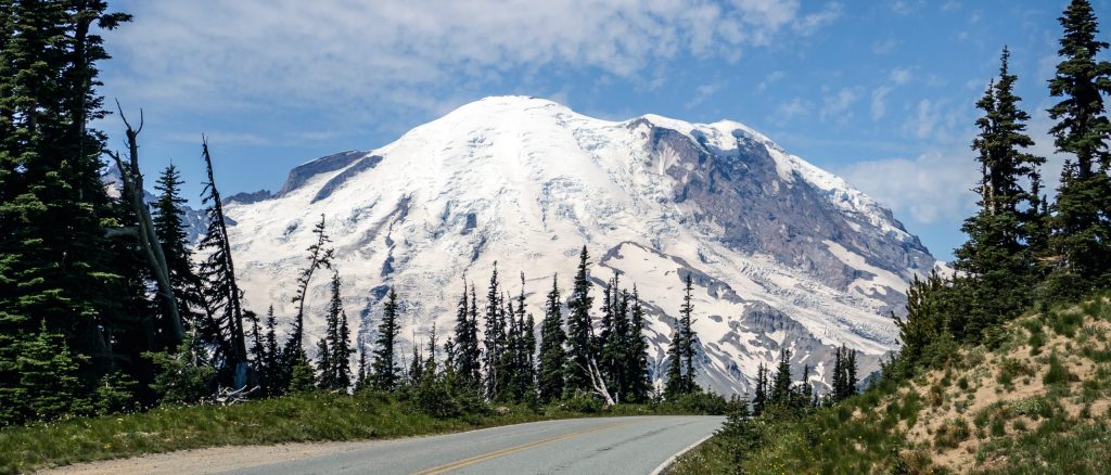 Image of Mount Rainier glacier in background with road in foreground.