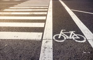 Bike lane symbol with crosswalk on asphalt street.