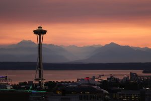 Image of downtown Seattle at dusk with mountains in background.