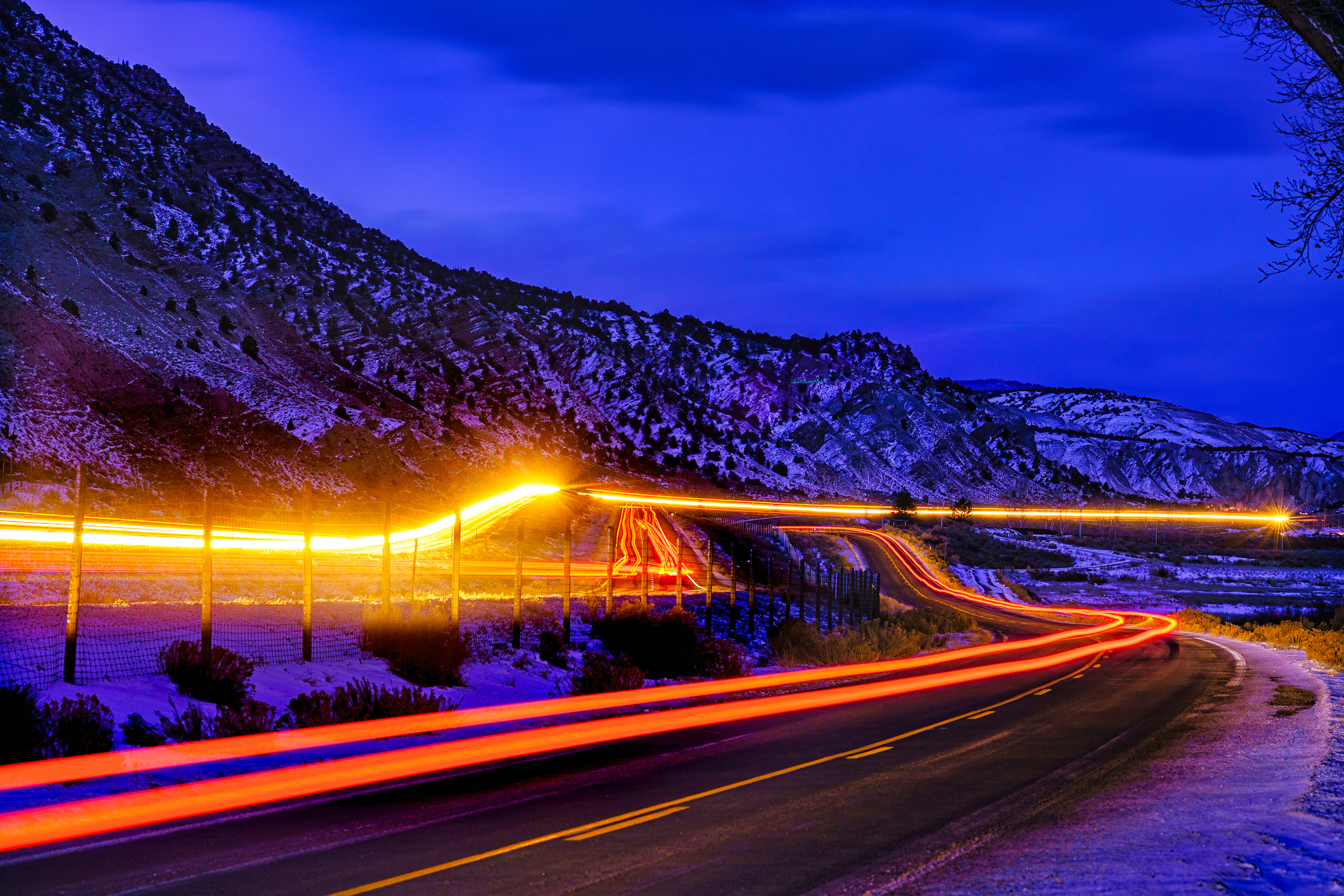 Lights at Night Road Time Exposure - Interstate 70 (I-70) between Dotsero and Gypsum Colorado. Roads with cars and lights traveling at dusk long exposure blue hour image. Light streaks from vehicles going east and west bound.