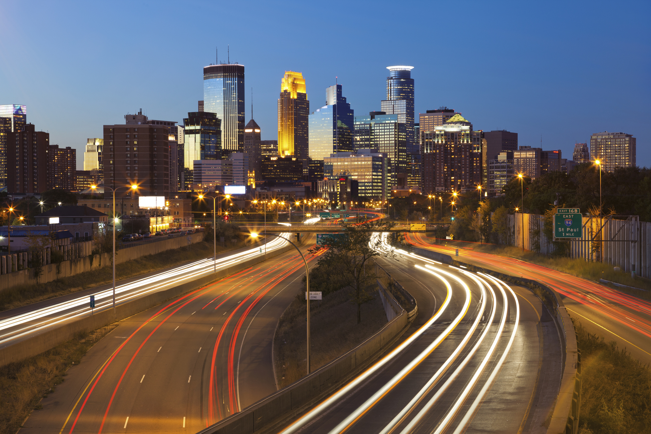 Image of Minneapolis skyline and highway with traffic lines leading to the city.