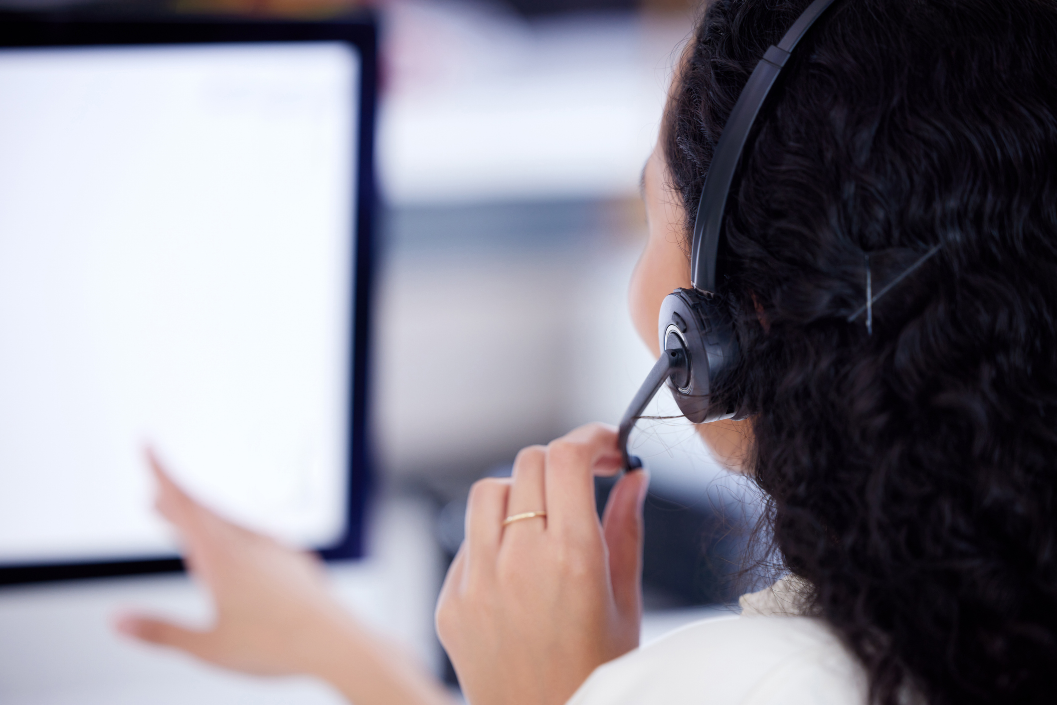 Person wearing a headset conducting a phone interview, representing the role of qualitative data collection through in-depth interviews in travel behavior research.