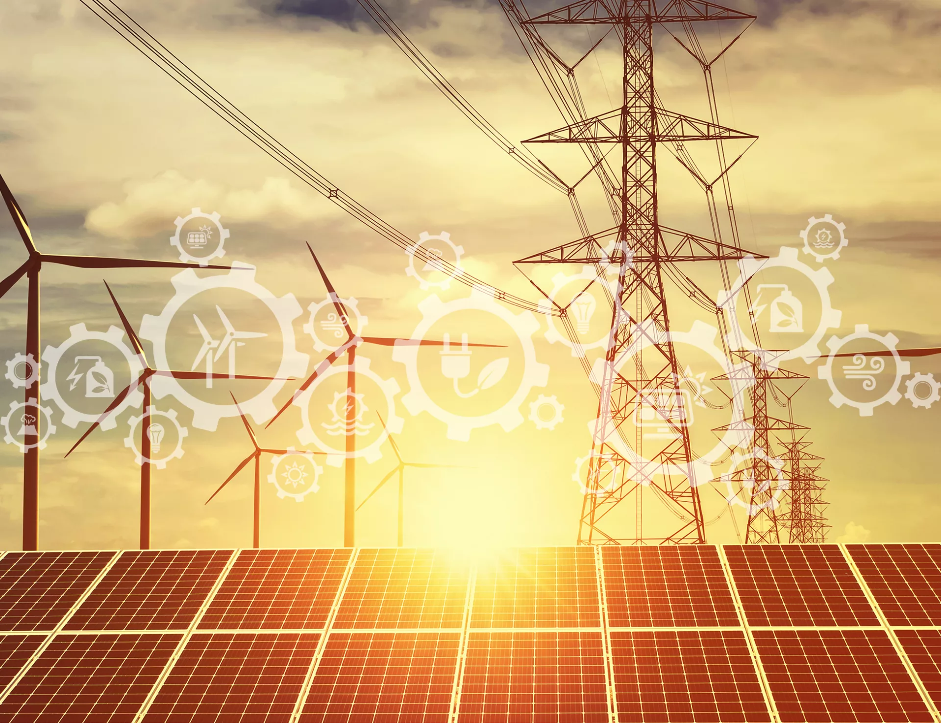 Sun rises over solar panels with wind turbines in the background alongside power lines leading from energy storage as part of renewable energy project.